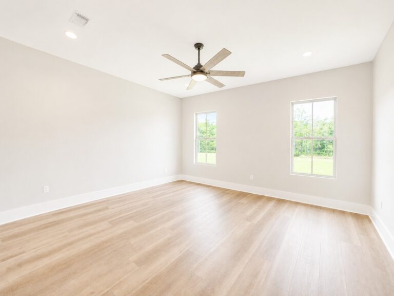 Primary bedroom with light wood-look flooring, neutral walls, recessed lighting, two windows, and a modern ceiling fan in the Cypress custom home at 12483 Alphabet Road in Florence Gardens, Gulfport, Mississippi 39503.