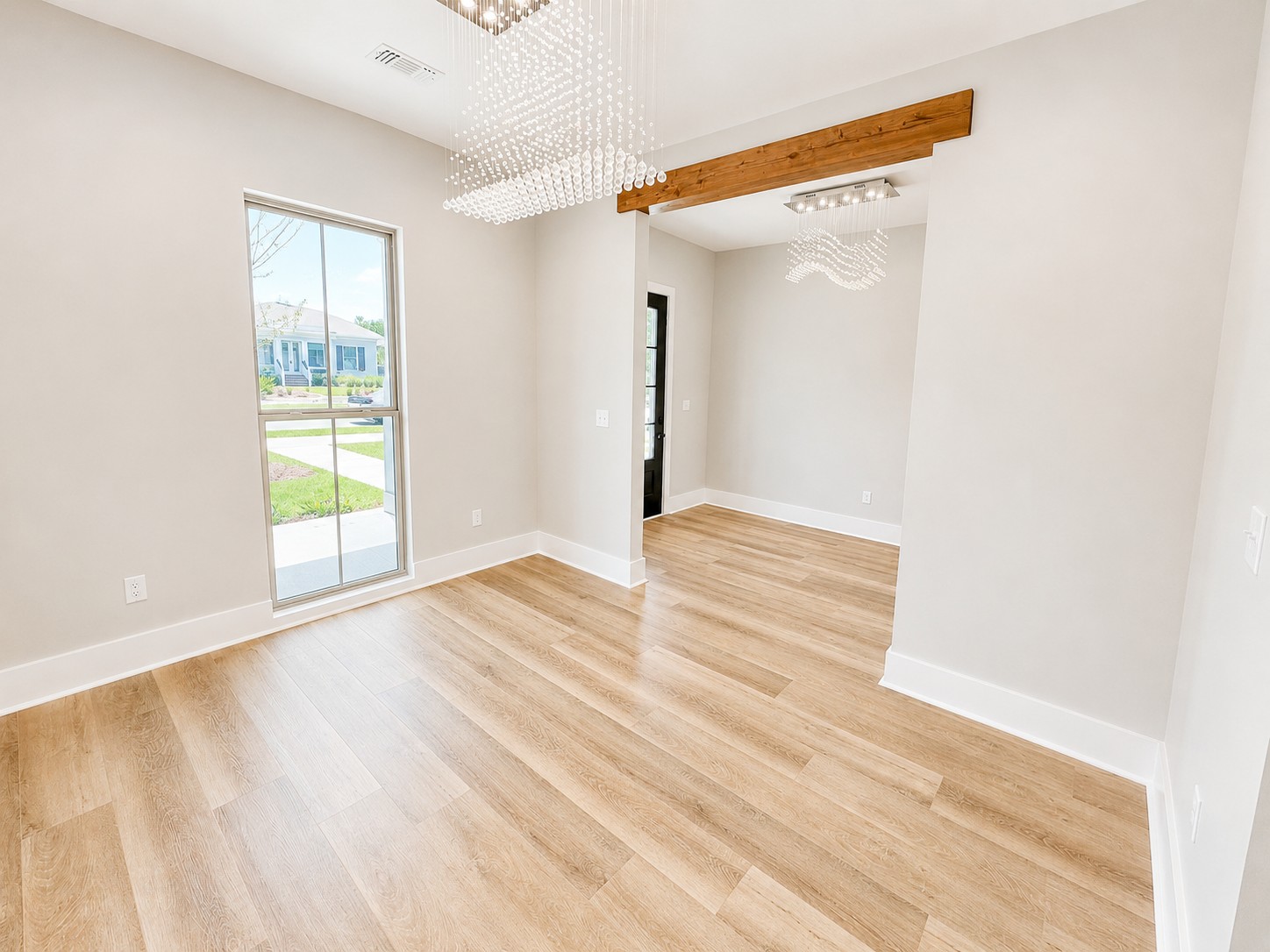 Dining room in the Cypress custom home at 12483 Alphabet Road in Florence Gardens, Gulfport, MS, featuring wood-look flooring, a modern chandelier, and cypress wrapped beams.