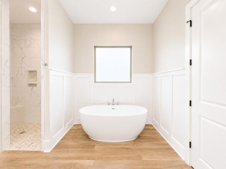 Freestanding soaking tub with decorative wall paneling/wanescoting, wood-look flooring, and an adjoining custom tiled shower to ceiling in the Cypress custom home at 12483 Alphabet Road in Florence Gardens, Gulfport, Mississippi 39503.