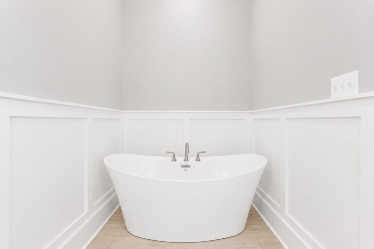Freestanding soaking tub with white wall paneling and brushed-nickel fixtures in the primary bathroom at 298 Porter Avenue in downtown Ocean Springs, Mississippi 39564